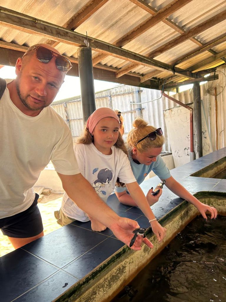 Holding a hatchling at the turtle hatchery